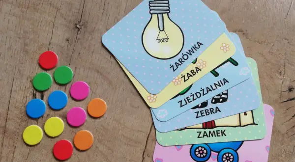 Kolorowe żetony i karty do gry "Zagadki smoka obiboka" z obrazkami żarówki, żaby, zebry, zamku i wózka.